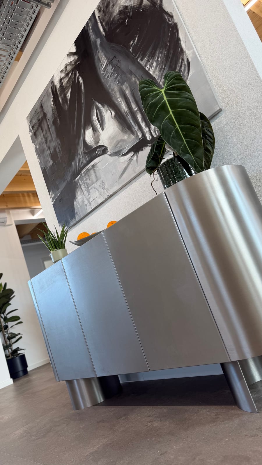 Großes Schwarz-Weiß-Gemälde über einem Sideboard aus gebürstetem Stahl